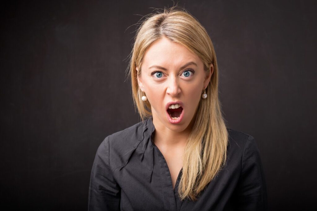 Anger and Stress Management A beautiful angry woman wearing black blouse with brown hair.