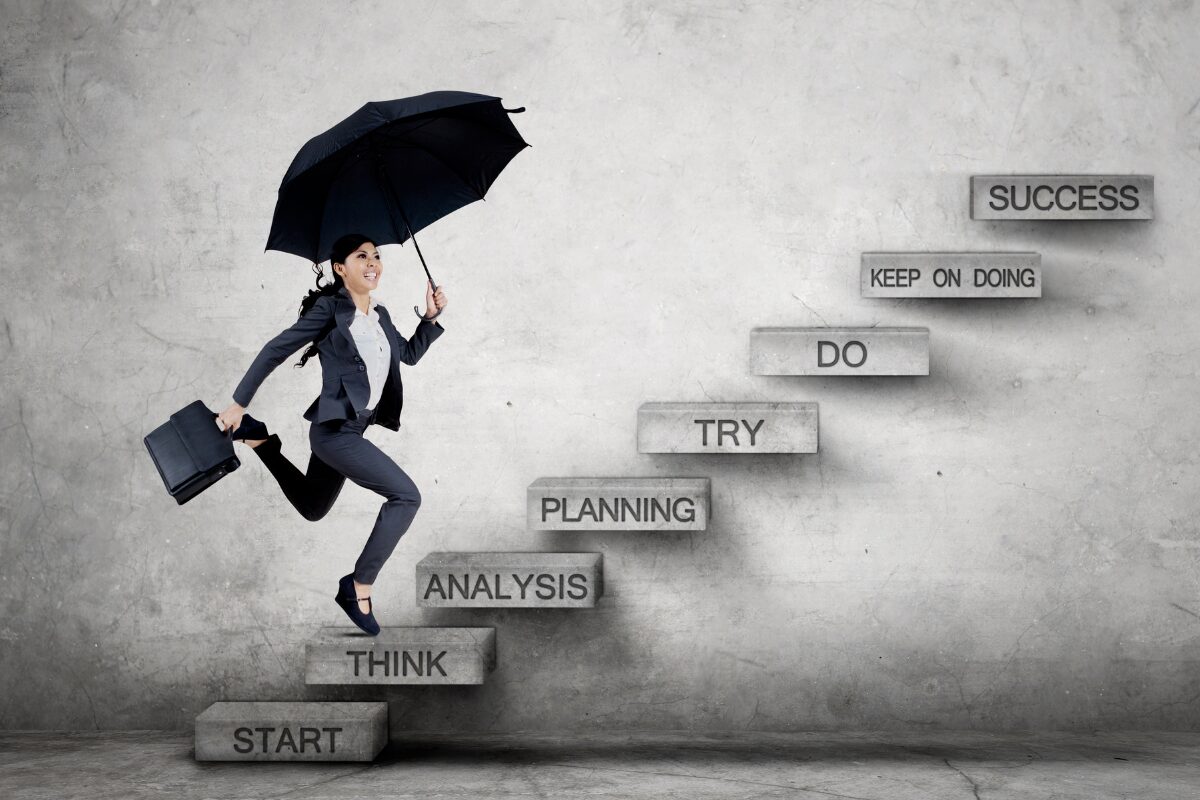 A woman in the stairs of a roadmap of success. How a simple shift in mindset can change your life forever.