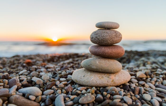how to do mindfulness for beginners A stack of stones on a bed of pebble in afternoon. How to do mindfulness for beginners