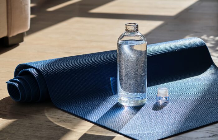 A bottled water with a yoga mat. Transform your tension: The secrets to effortless stress management.